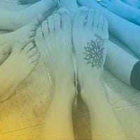 A group of dancer's feet with a tattoo of a flower on one