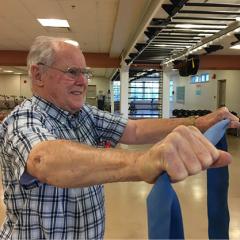 Man exercising with elastic tubing