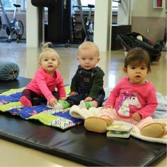 Image of 3 toddlers in the fitness studio as part of Baby and Me fitness class.