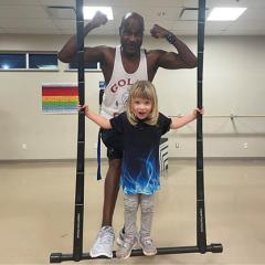 Girl with personal trainer showing muscles