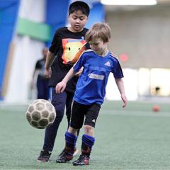 2 boys playing soccer