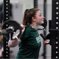 Girl lifting barbell in weightroom